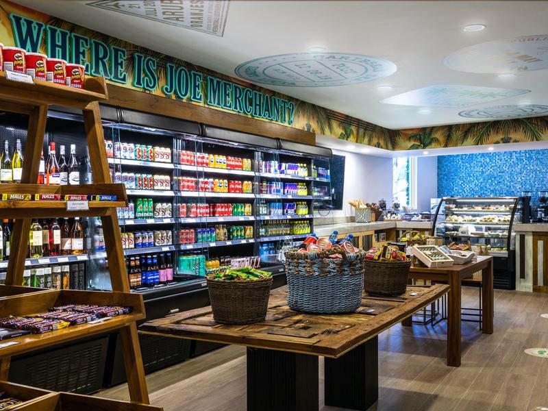 Un negozio moderno interno con scaffali pieni di prodotti colorati e un tavolo con cestini.