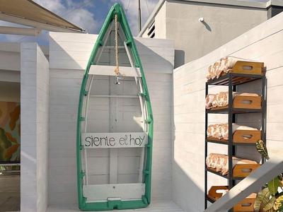 Grünes Boot hängt an einer weißen Wand im Außenbereich eines Hotels.