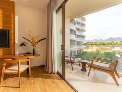 Modern ingerichte kamer met werkruimte en balkon met zitgelegenheid en uitzicht op het landschap.