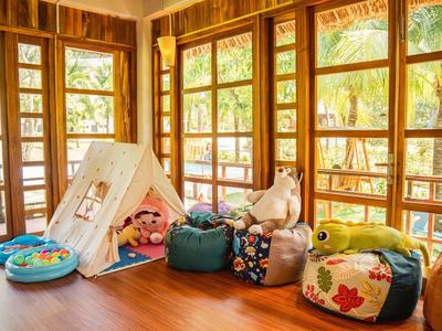 Lichte, gezellige kamer met houten ramen, zitzakken en een kleine speeltent.