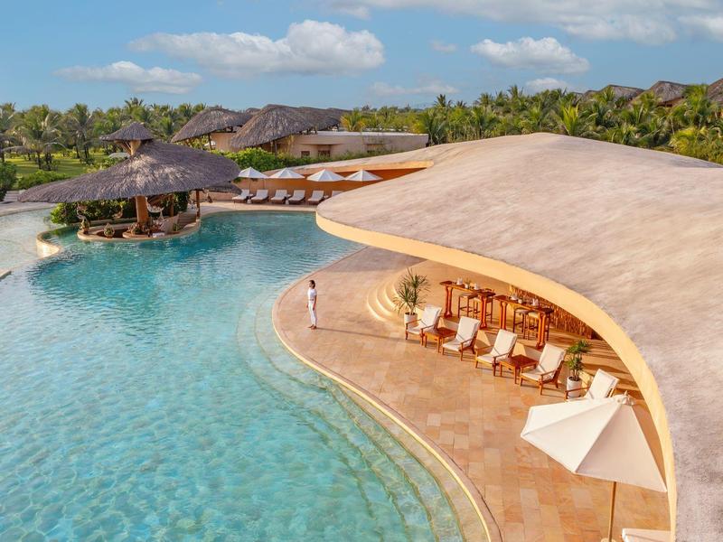 Luxe zwembad met bar en ligstoelen op een zonnige vakantiebestemming.