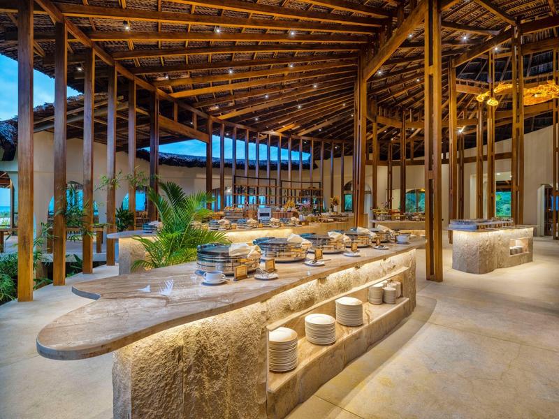 Open hotelresort met natuurlijke houten meubels en tropische decoratie.