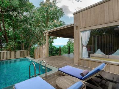 Nowoczesny drewniany bungalow z basenem na tarasie i widokiem na zalesione wzgórza.