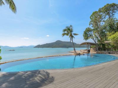 Infinity-Pool mit Blick auf das Meer und Palmen an einem sonnigen Tag