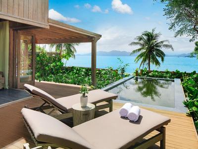 Nowoczesny pokój hotelowy z tarasem, leżakami i basenem infinity z widokiem na morze.