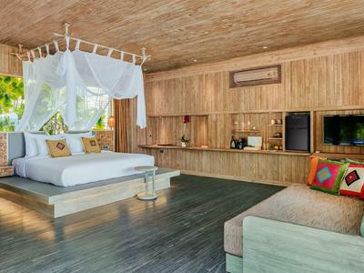 Przestronny pokój hotelowy z drewnianą boazerią, łóżkiem z baldachimem i przytulnym miejscem do siedzenia.