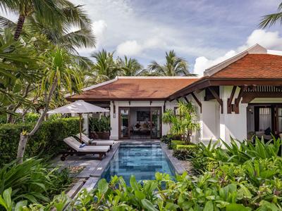 Luxuriöse Villa mit kleinem Pool, Sonnenliegen und üppiger tropischer Begrünung.