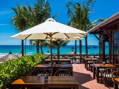 Terrazza di un ristorante sulla spiaggia con ombrelloni e vista sul mare