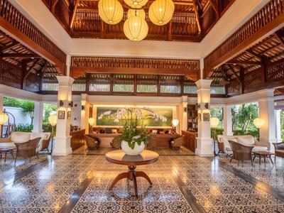 Großer, offener Raum mit warmem Holzdekor, gemusterten Fliesen und gemütlichen Sitzgruppen.