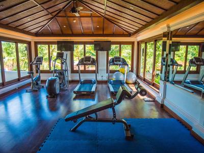 Helles Fitnessstudio mit modernen Geräten und großen Fenstern mit Blick ins Grüne.