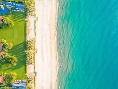 Moderner Innenhof mit Wasserspiel, großen Vasen, Holz- und Glaselementen, umgeben von grünem Pflanzenreich.