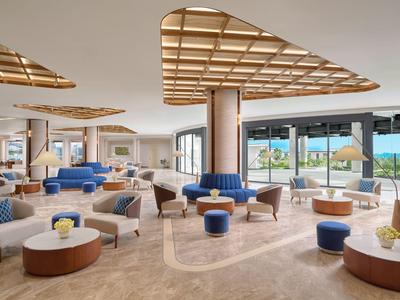 Salon d'hôtel moderne avec sièges confortables et vue sur la mer.