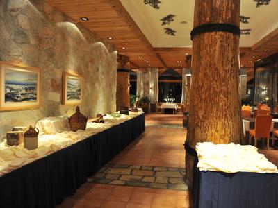 Rustikale Hotellobby mit Holzbalken, warmen Lichtakzenten und dekorativen Elementen auf einem langen Tisch.