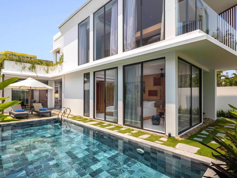 Casa moderna de dos pisos con grandes ventanas de vidrio y piscina privada al aire libre.