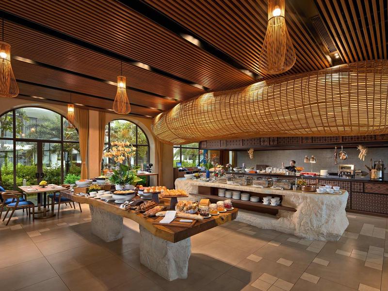 Moderna zona de desayuno con buffet, muebles de madera y grandes ventanas al jardín.