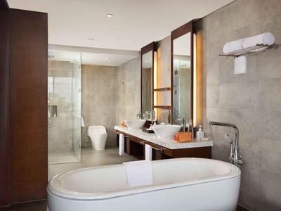 Baño moderno con bañera independiente, lavabo doble y ducha de cristal.