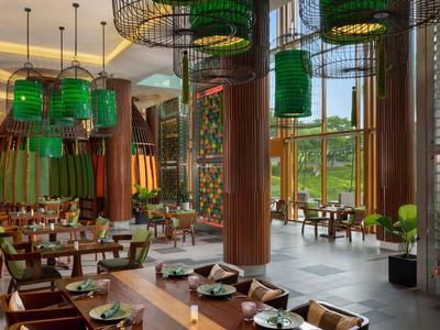 Restaurante moderno con pantallas de lámparas verdes y grandes ventanas con vistas a la naturaleza