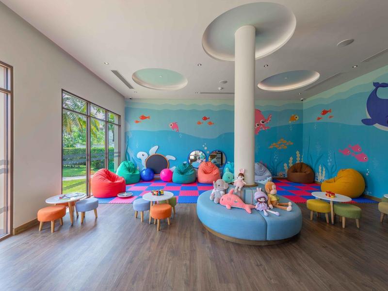 Una sala giochi colorata con pouf e giocattoli per bambini in un hotel.
