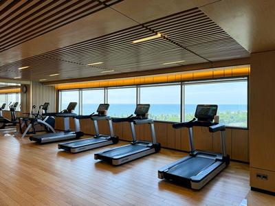 Modernes Fitnessstudio mit Laufbändern vor großen Fenstern und Panoramablick.
