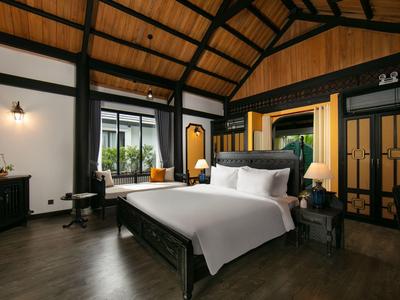 Luxe slaapkamer met houten balkenplafond en groot bed, elegant ingericht.