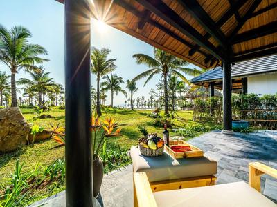 Terrasse mit Holzdach, Liegestuhl, Tisch, exotischer Garten mit Palmen und Sonnenlicht am Nachmittag.