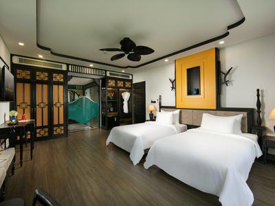 Moderne hotelkamer met twee eenpersoonsbedden, houten vloer en Aziatisch geïnspireerd decor.