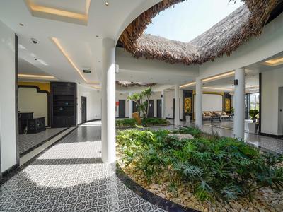 Moderne hotelbinnenplaats met centrale begroeiing en overdekte open daklicht.