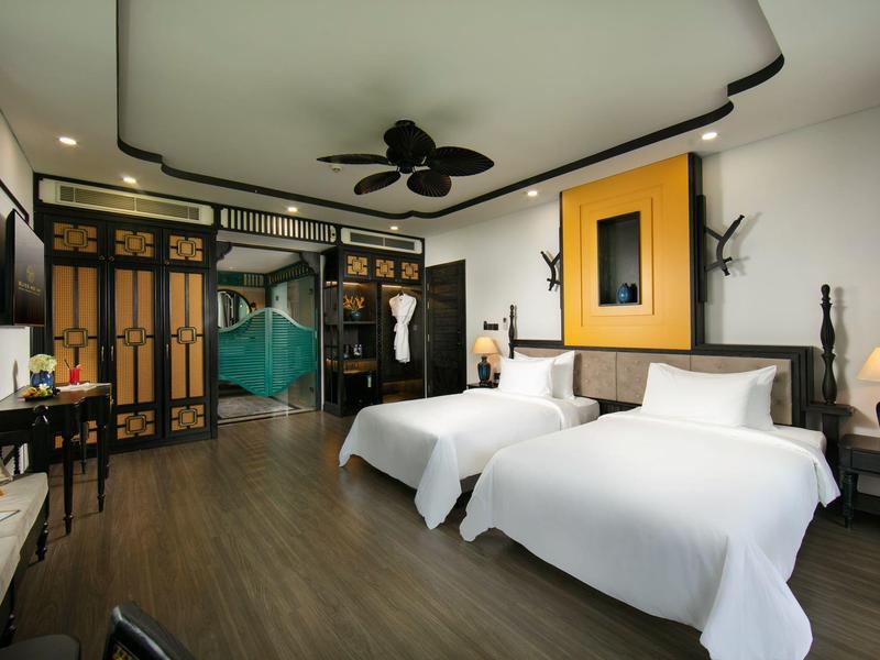 Moderne hotelkamer met twee eenpersoonsbedden, houten vloer en Aziatisch geïnspireerd decor.