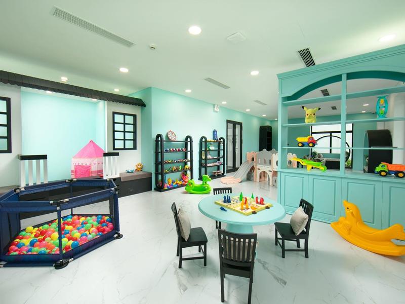 Heldere kinderkamer met kleurrijk ballenbad, speelgoed en kindermeubel met stoelen.