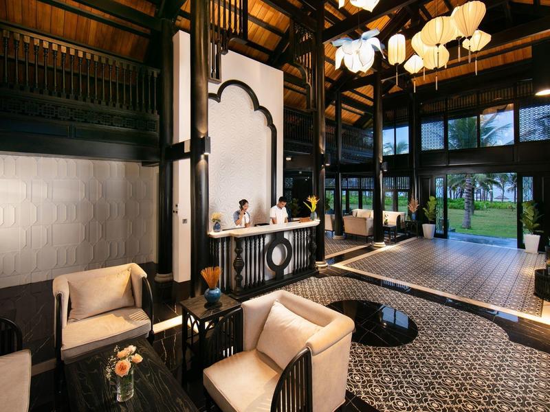 Elegante hotel lounge met comfortabele fauteuils, grote ramen en uitzicht op de tuin.