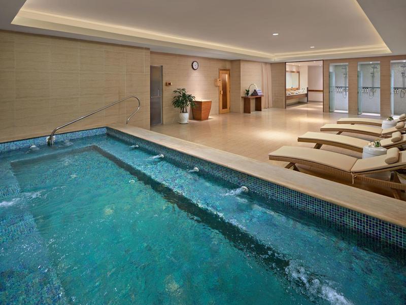 Piscina interna moderna con lettini e atmosfera rilassante in un hotel.