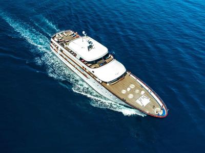 Luxusyacht fährt auf offenem, tiefblauem Meer bei sonnigem Wetter.