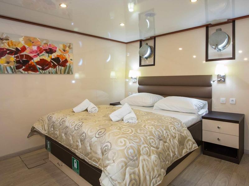 Modern hotel room with double bed, nightstands, and decorative wall art.