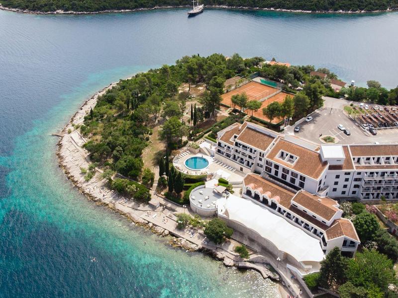 Widok z lotu ptaka na hotel nadbrzeżny z basenem i okalającym lasem