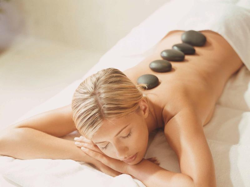 Woman receiving hot stone massage in a calm spa setting