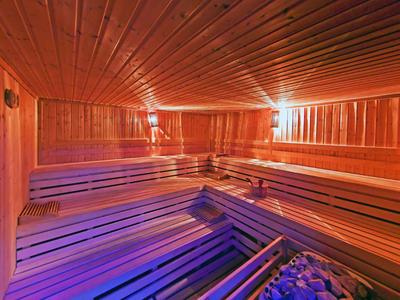 Binnenkant van een sauna met houten bekleding en warm licht.