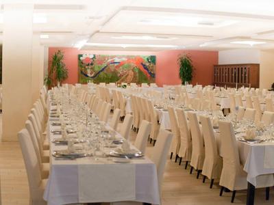 Elegante banketzaal met een lange, feestelijk gedekte tafel en comfortabele stoelen.