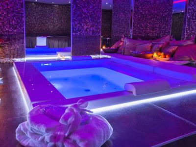 Luxe bubbelbad met sfeerverlichting en kaarsen in een ontspannen omgeving.