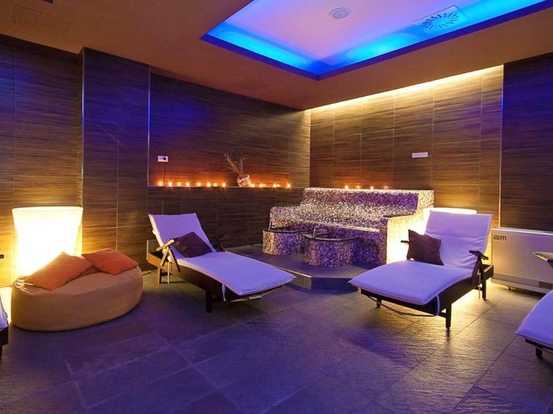 Gezellige wellnessruimte met open haard, schemerverlichting en comfortabele ligstoelen.