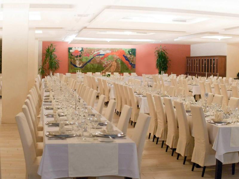 Elegante banketzaal met een lange, feestelijk gedekte tafel en comfortabele stoelen.