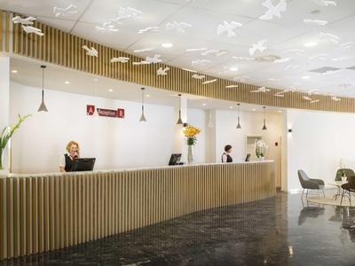 Rezeption eines modernen Hotels mit langer Holztheke und entspannter Atmosphäre.