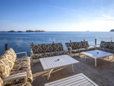 Terrasse mit gemütlichen Sitzgruppen und Meerblick unter klarem Himmel