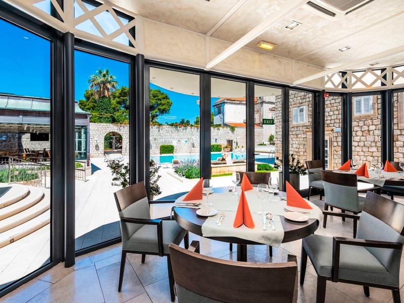 Ristorante moderno con tavoli rotondi e vista sul cortile interno dell'hotel.