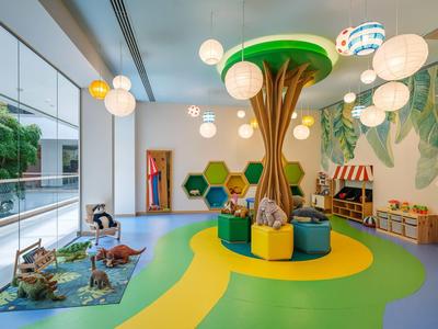 Area giochi per bambini con panchina a forma di albero e giocattoli colorati in una stanza moderna.