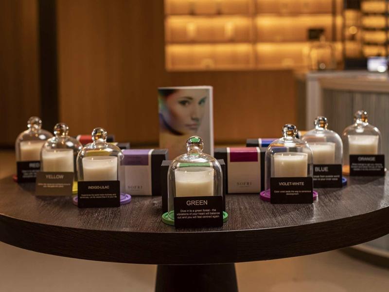 Flaconi di profumo eleganti disposti su un tavolo rotondo in legno.