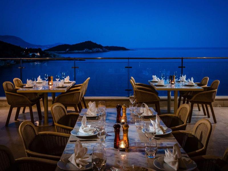Ristorante elegante sulla terrazza con vista sulla costa di notte.