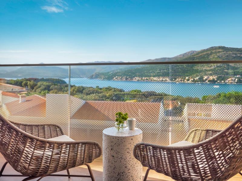 Terrazza con due sedie, tavolino e vista sul mare e sulle colline