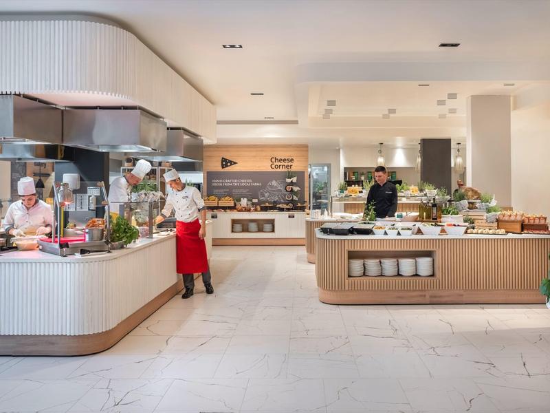Ristorante moderno dell'hotel con buffet e chef al lavoro.