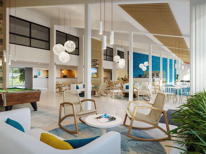 Lounge d'hotel moderna con poltrone accoglienti, tavoli e illuminazione decorativa