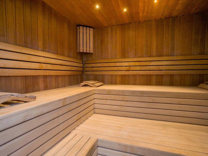 Interno sauna in legno con panche a gradini e illuminazione soffusa